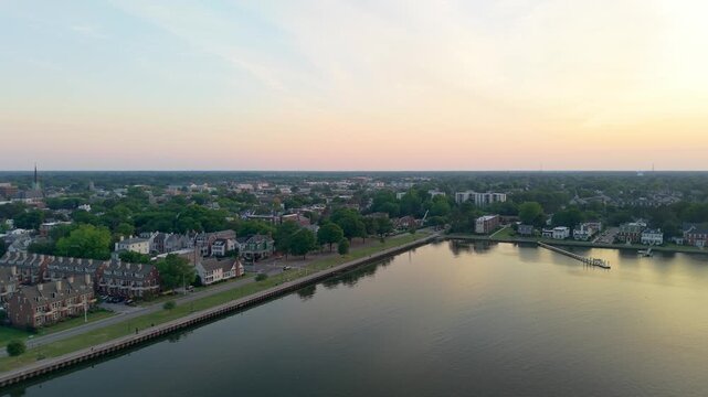 Portsmouth, Virginia, scenic 4K aerial video establishing the historic Olde Towne waterfront and residential district along the Elizabeth River during a quiet golden hour sunset.