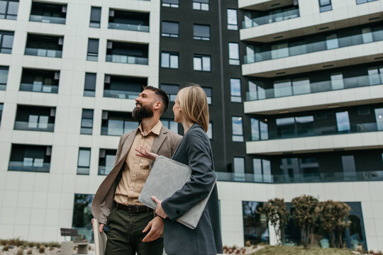 Business professionals discussing property outside modern building