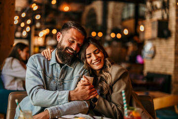 Obraz premium Happy young couple dating and embracing in restaurant