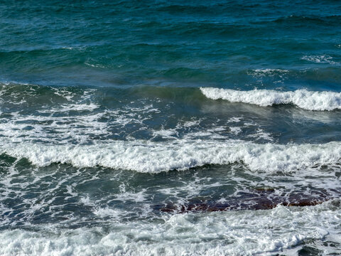 Waves breaking on the Aegean Sea shore near Vouliagmeni in Attica Greece on a windy day