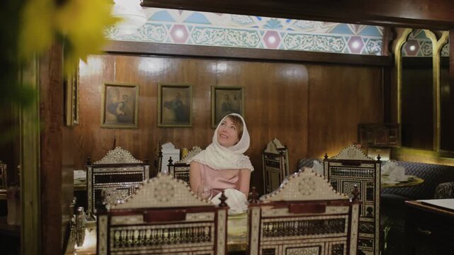 4K travel video in Cairo, Egypt, with cinematic focus transition from bright sunflowers to a smiling woman sitting in a traditional oriental restaurant interior.