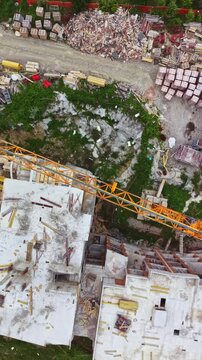 Construction is taking place on a multi-storey building. Cranes are in use and materials are scattered around the site. The area shows signs of ongoing work and development.