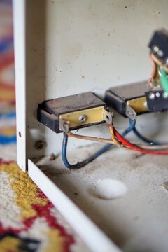 Internal electrical wiring and switch terminals inside a dirty metal casing of a stavolt stabilizer.