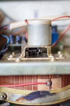 Detailed view of a small servo motor and metal gears mechanism inside an automatic voltage regulator.