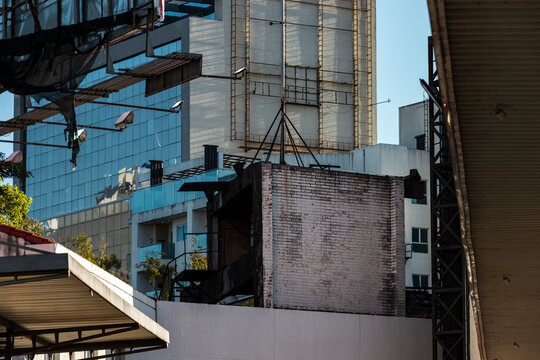 Dense urban rooftop layers brick wall, glass facade, and industrial metal frame