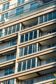 Repeating balcony grid and glass lines shape dense residential facade