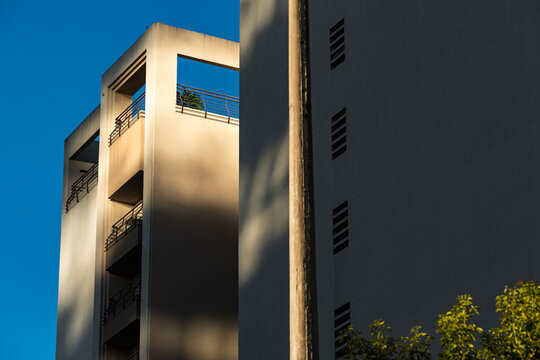 Streetlight divides geometric residential forms against open blue sky