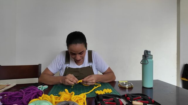 Woman making diy macrame flower decorations at home