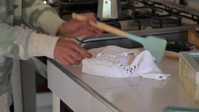 4k video of a woman preparing pancakes, taking them out of the pan and placing them on a napkin to keep them warm.
