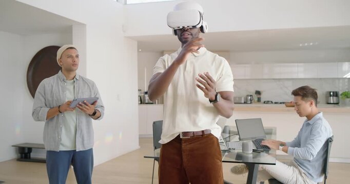 Diverse male team running VR test in loft, center African-American man in VR headset gesturing