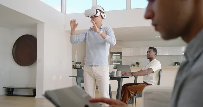 Diverse men at home standing man donning VR headset interacting with virtual world others on tablet