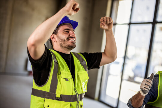 Close-up of a happy construction worker celebrating success on site.