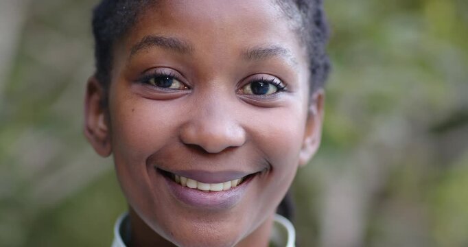 Woman maintaining eye contact with camera while smiling, then laughing in park with collared top