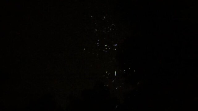 Shimmering rain drops against dark night sky fluctuating from regular speed to super slow motion. 