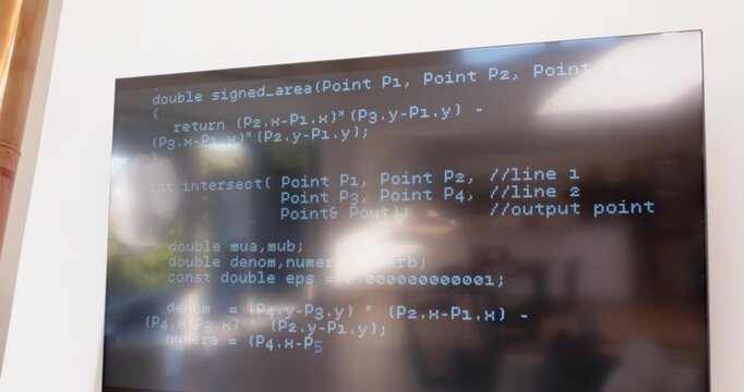 Hand cam is shifting down, revealing lower code on screen and glare reflecting blurred meeting room