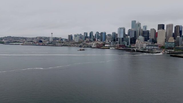 Aerial drone view of Seattle skyline across Elliott Bay with downtown skyscrapers and waterfront