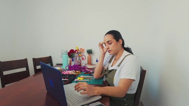 Stressed female entrepreneur working from home on laptop computer