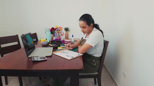 Focused woman working remotely from her dining room table