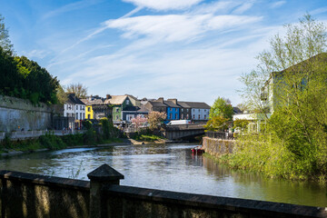 Fototapeta premium Colorful terraced houses along scenic river with bridge in Irish town