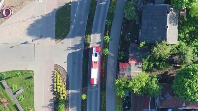Bus riding through city, aerial top down view