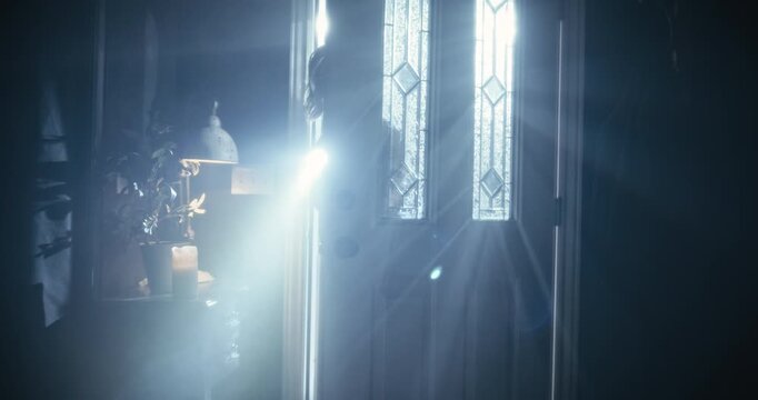 Cinematic silhouette of woman with flashlight entering hazy, dark home with caution - dolly in shot