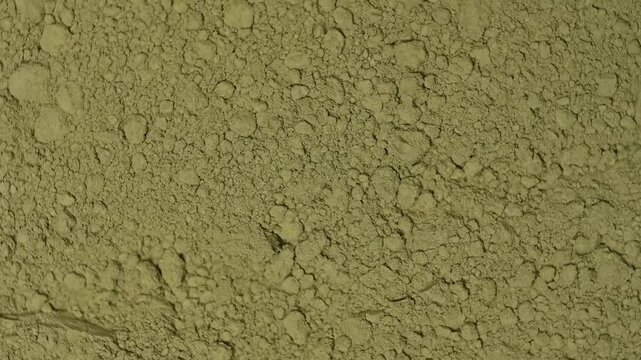 Top view macro shot of fine organic green matcha tea powder rotating slowly. Premium Japanese culinary ingredient texture background
