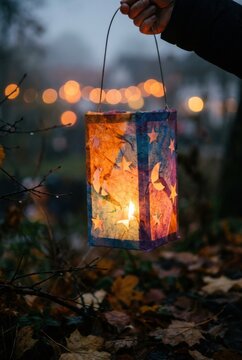 Bunte Papierlaterne mit Sternen und Mond bei nebliger Abendstimmung im Garten