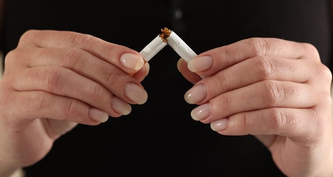 Woman breaking cigarette, closeup. Quitting bad habit