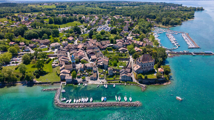 Drone overview of a medieval town with sailboats anchored in a beautiful harbor on a sunny day © Christopher