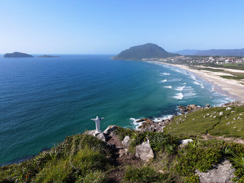 Panoramic view from Morro dos Ingleses mountain with Christ Redeemer statue overlooking Santinho beach and Costao resort in Florianopolis, Brazil