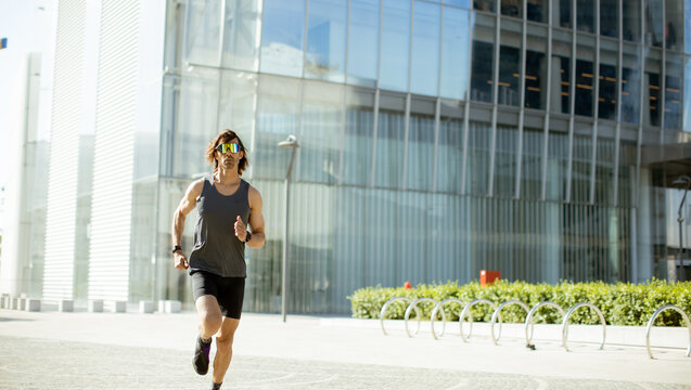 Runner moves swiftly in cityscape during bright daylight hours