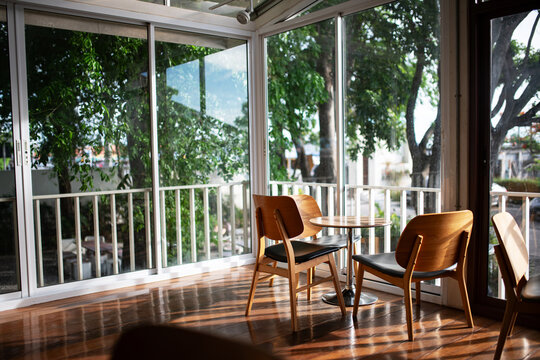 Cozy Sunlit Dining Area with Large Windows and Garden View