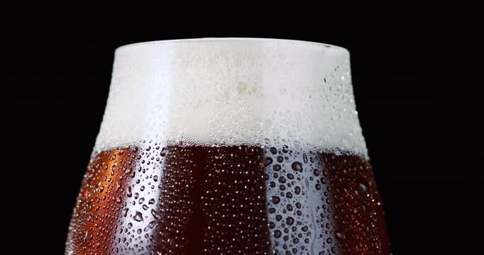 Close-up of Cold Dark Beer with Thick White Foam and Condensation
