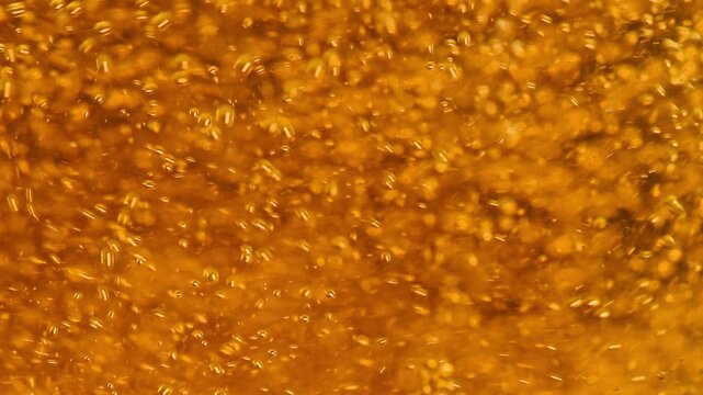 Extreme Macro of Golden Beer Bubbles Rising with White Foam 
