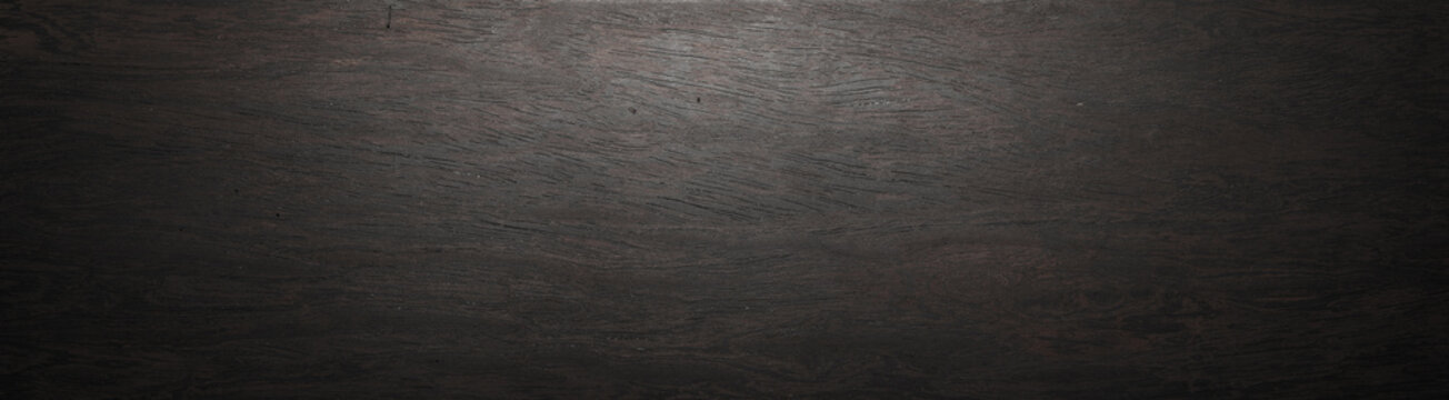 Dark ebony wood plank texture against a long background. Wood grain. dark grunge background with grunge texture
