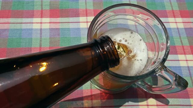 Pouring Cold Craft Beer from Bottle into Glass on Rustic Table


