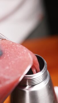 Chef vertiendo l&iacute;quido en un sif&oacute;n para crear espuma culinaria. Chef profesional llenando un sif&oacute;n con una mezcla l&iacute;quida. Gastronom&iacute;a molecular, t&eacute;cnica de espuma vanguardista.