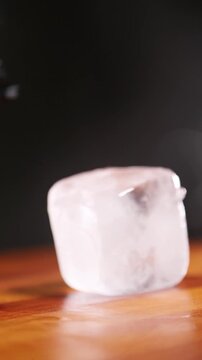 Barman preparando un cubito de hielo a mano. Barman profesional dando forma a un cubito de hielo con sus propias manos. C&oacute;ctel artesanal, preparaci&oacute;n de hielo artesanal.