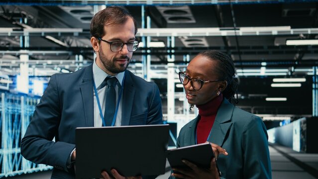 Data center engineering team using AR tech, working together to futureproof company network, Teamworking server room colleagues brainstorm, using devices to increase cybersecurity protection.