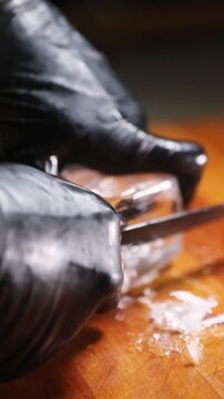 Barman tallando y dando forma a un cubo de hielo para c&oacute;ctel. Barman profesional cortando y perfilando un cubo de hielo a mano. C&oacute;ctel artesanal, t&eacute;cnica de tallado de hielo artesanal.