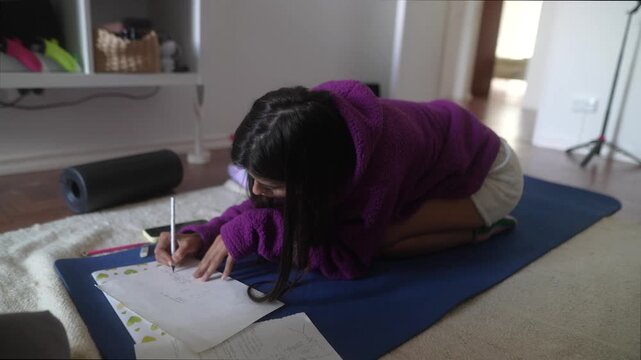 Woman peacefully penning thoughts on journal in cozy living area