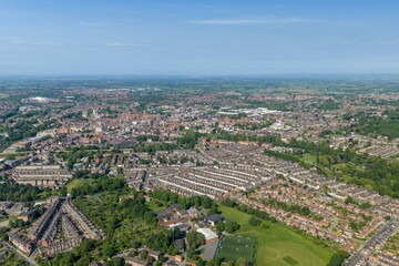 Obraz premium Panoramic aerial drone view of the historic city of York North Yorkshire England showing York Minster residential housing green parkland and countryside beneath a clear blue sky in the summer time