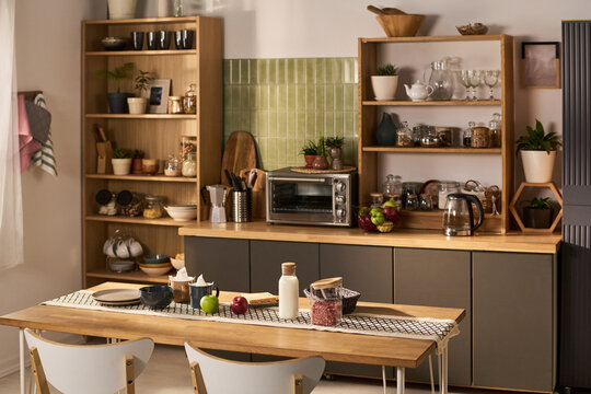Wide shot of modern home kitchen featuring organized cookware, small appliances, dining setup, and pantry storage. Supporting interior design, real estate, home living marketing