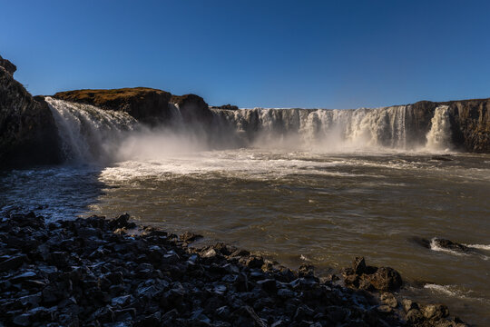 Cascade puissante dans un paysage naturel sauvage avec embruns et ciel d&eacute;gag&eacute;. Godafoss, Islande
