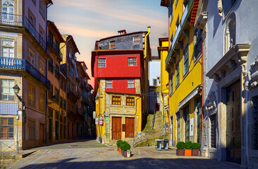 Fototapeta premium Porto, Portugal. Square with traditional houses with walls, covered with decorative portuguese tiles. Warm sunset evening time.