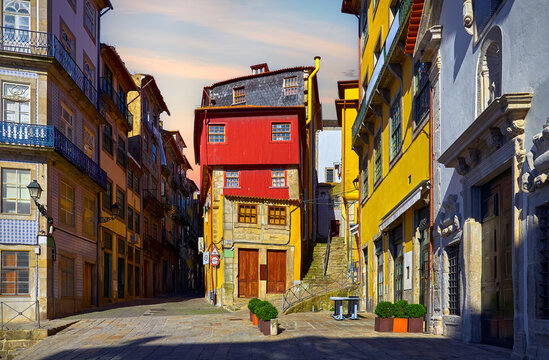 Porto, Portugal. Square with traditional houses with walls, covered with decorative portuguese tiles. Warm sunset evening time.