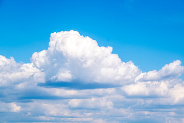 Bright Blue Sky With Large Fluffy Cumulus Clouds Over Calm Horizon