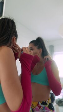 Women preparing for day by fixing earrings and clothing