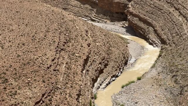 Zoom-out to Turtle Back rock formation with winding river canyon in Upper Dades Valley Morocco