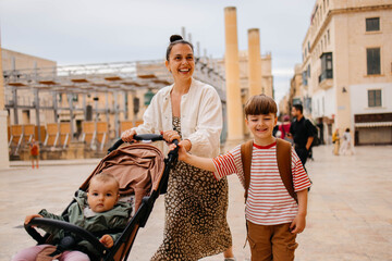 Naklejka premium Mother and two twin kids travelers